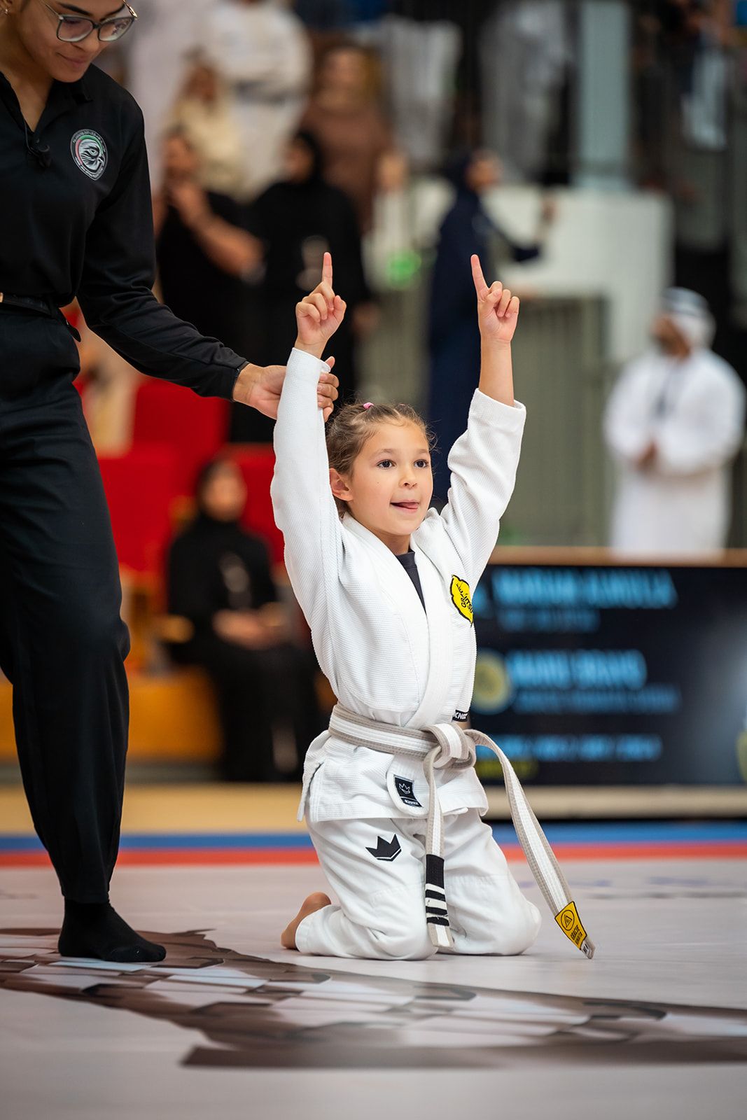 Young Jiu-Jitsu competitor celebrating her victory on the mats