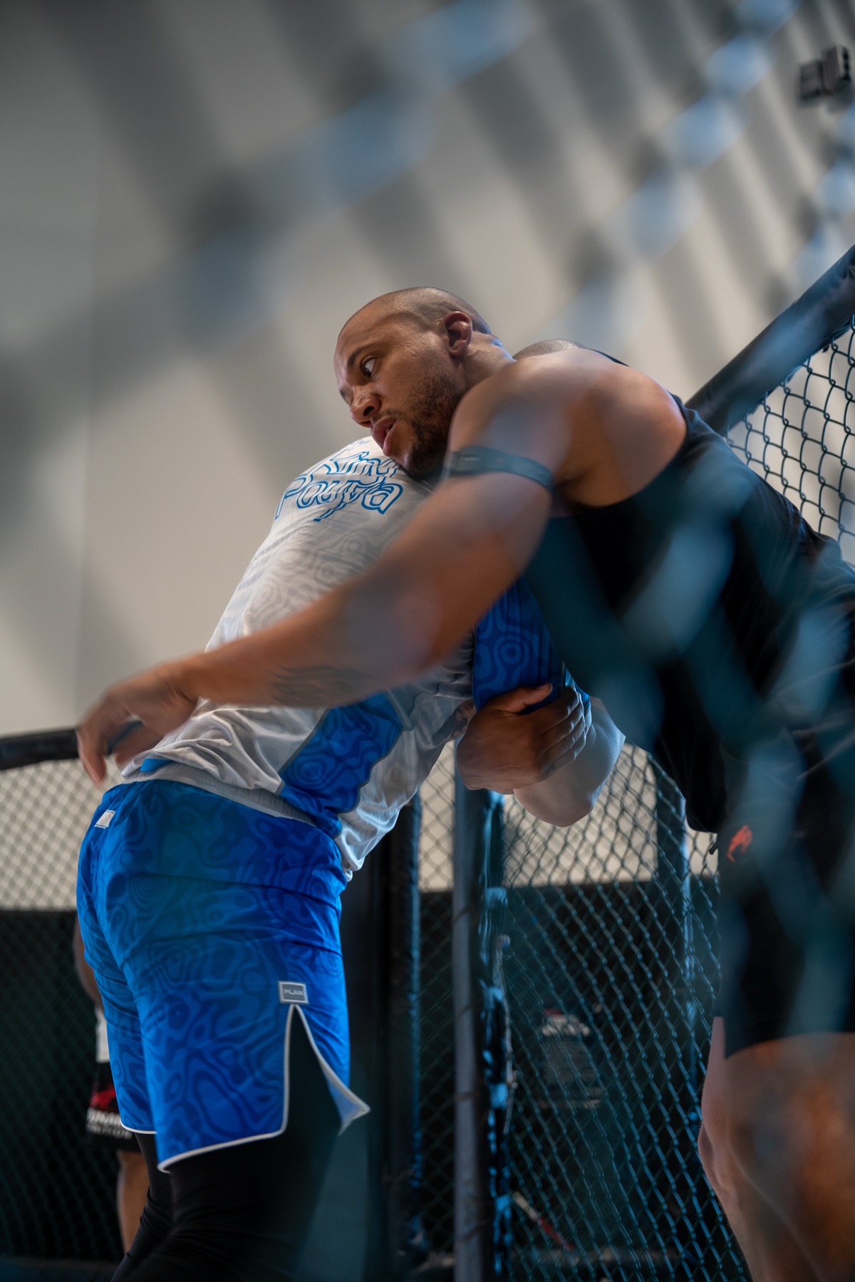 MMA fighter clinching against the cage, captured by Loopshoot