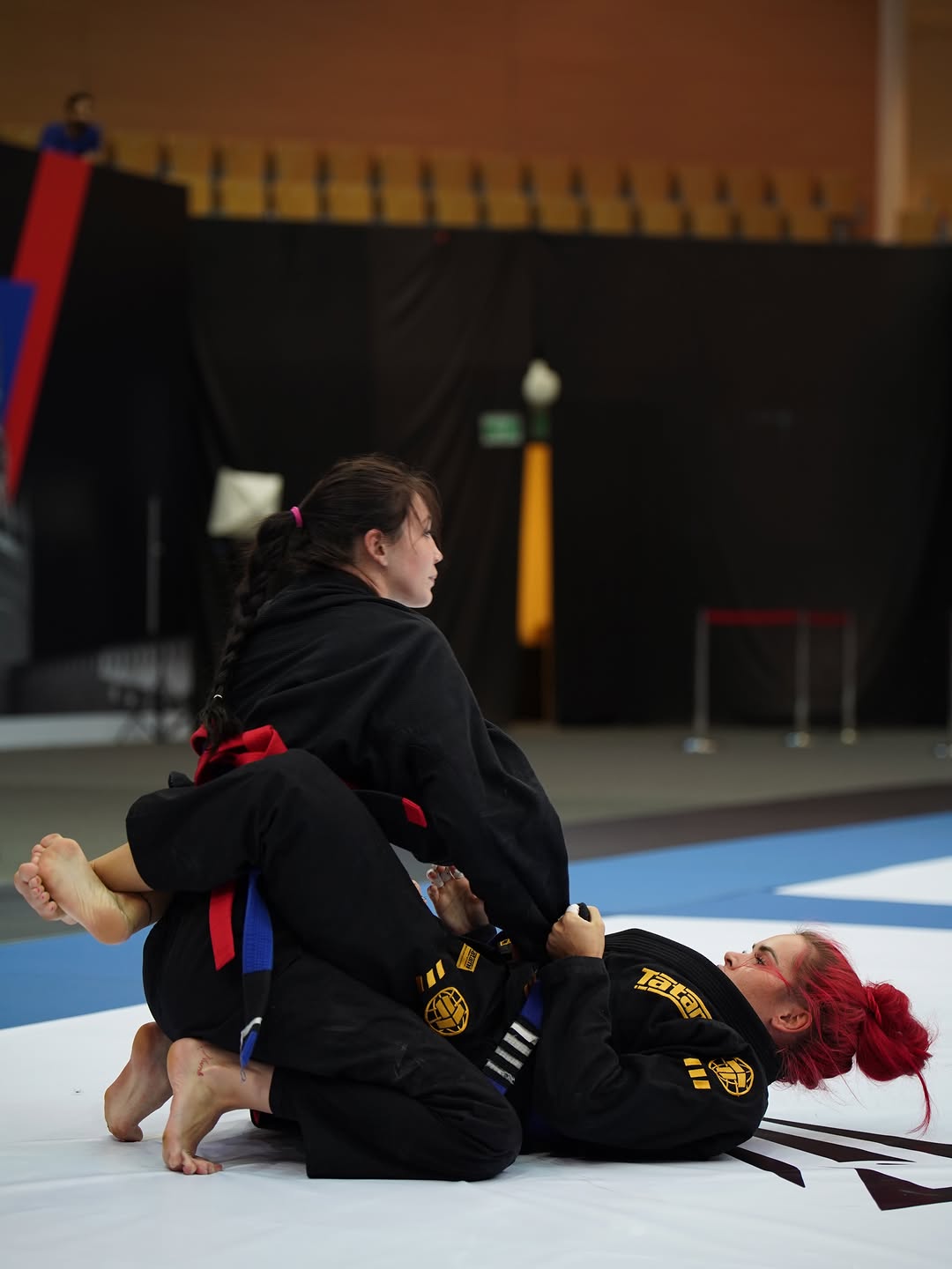 Jiu-Jitsu athletes grappling on the competition mats